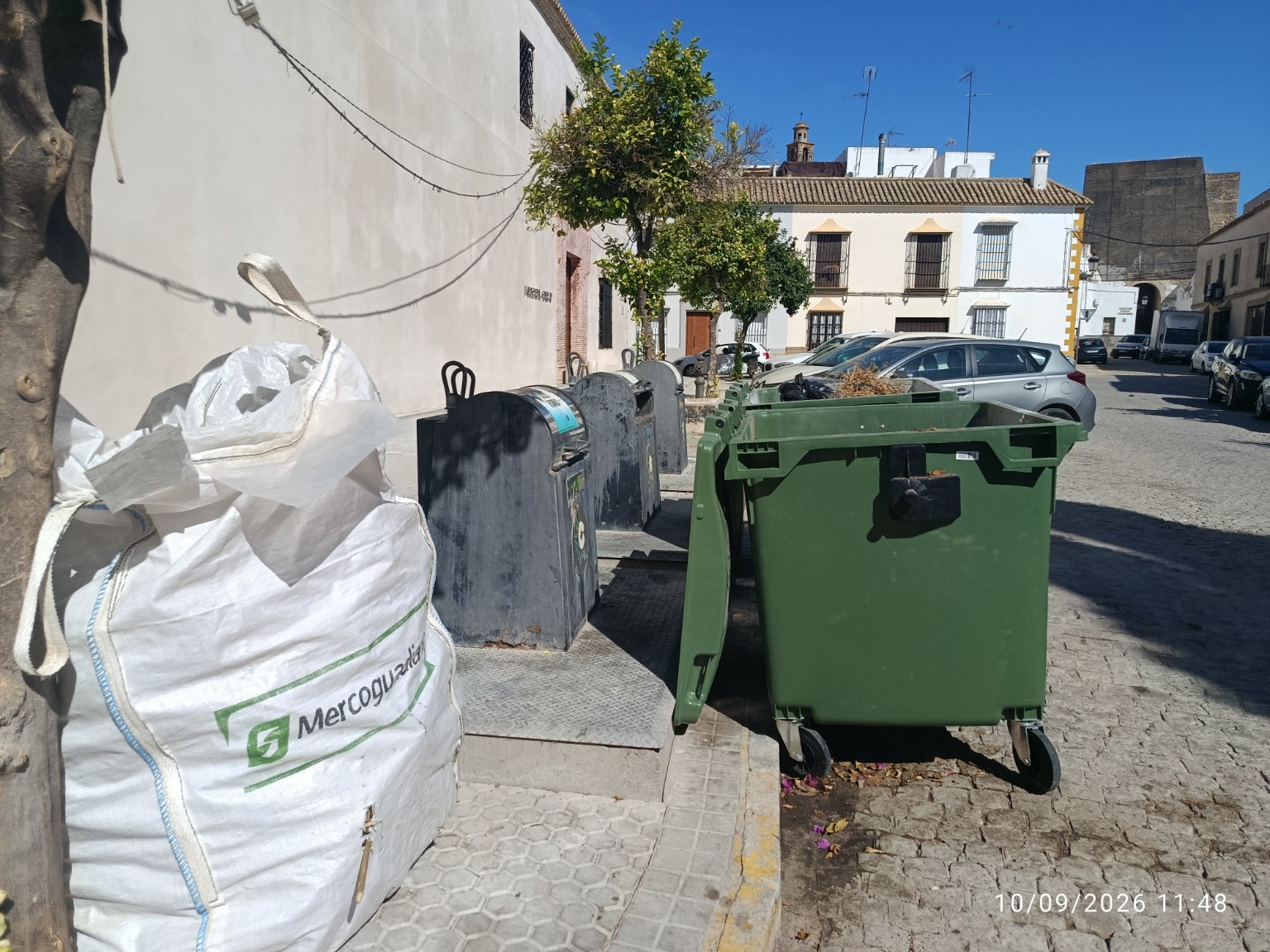 Contenedores de superficie junto a los buzones de contenedores soterrados en la plaza de la Cárcel del barrio de San Juan de Marchena