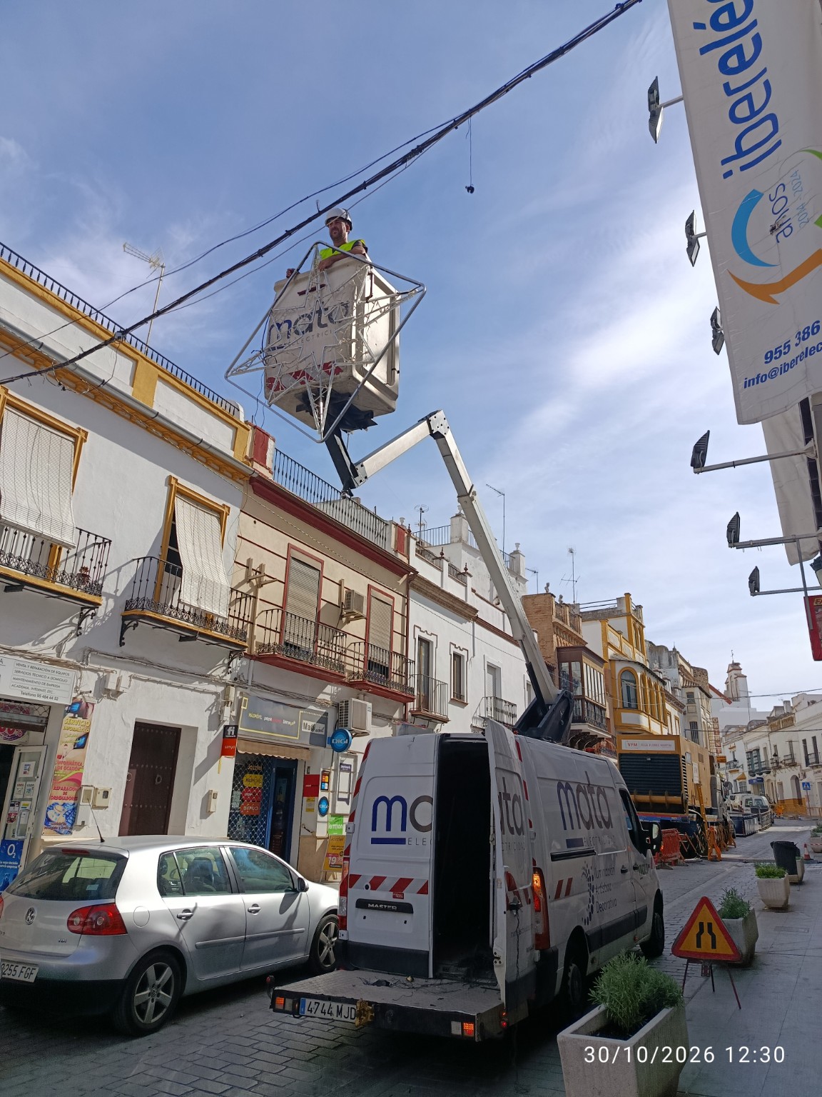 Instalación del alumbrado navideño con plataforma elevadora en la calle Rojas Marcos de Marchena, 30 de octubre de 2026
