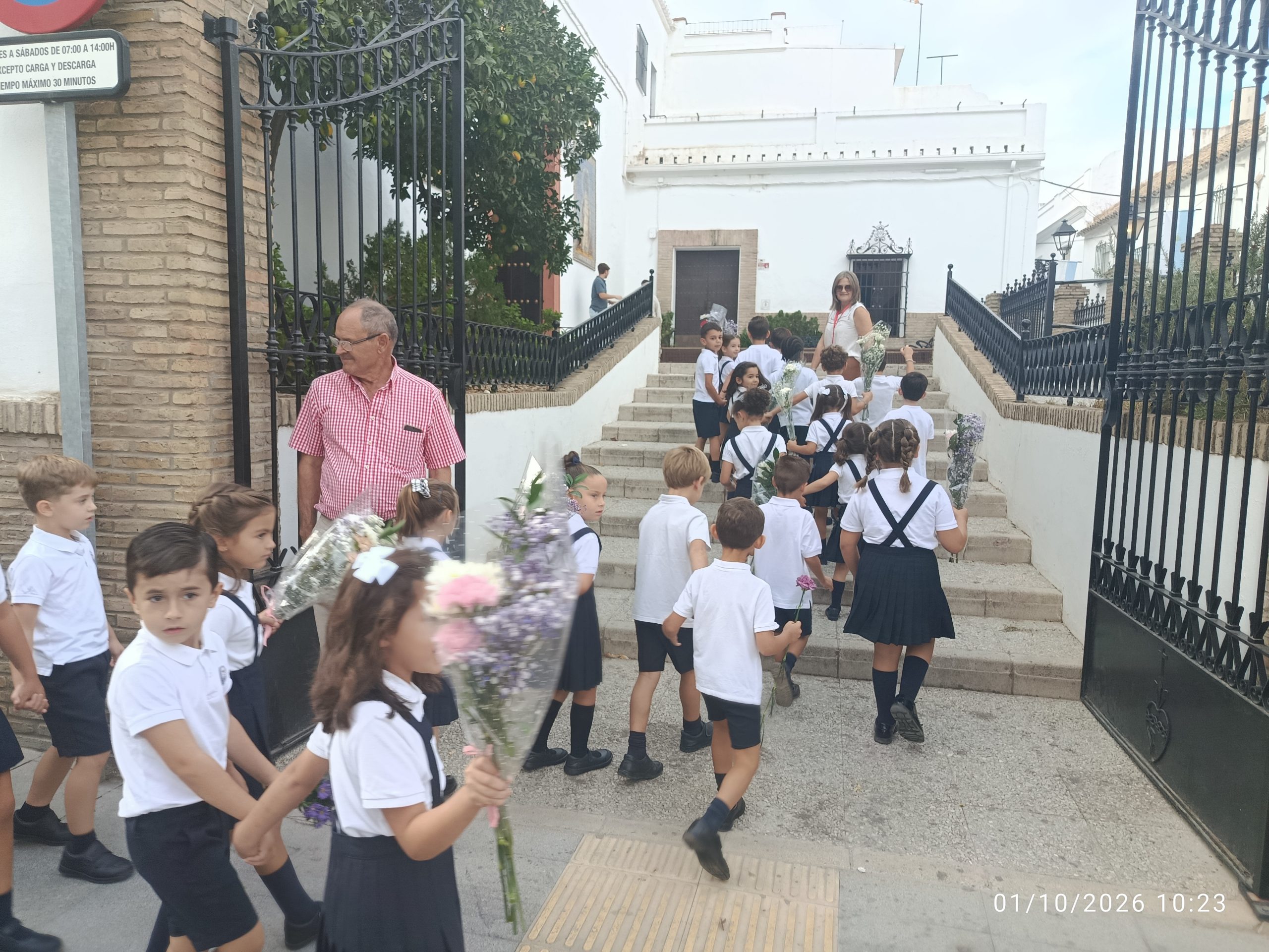 Escolares de Marchena con flores en Santo Domingo durante el inicio del triduo de la Virgen del Rosario