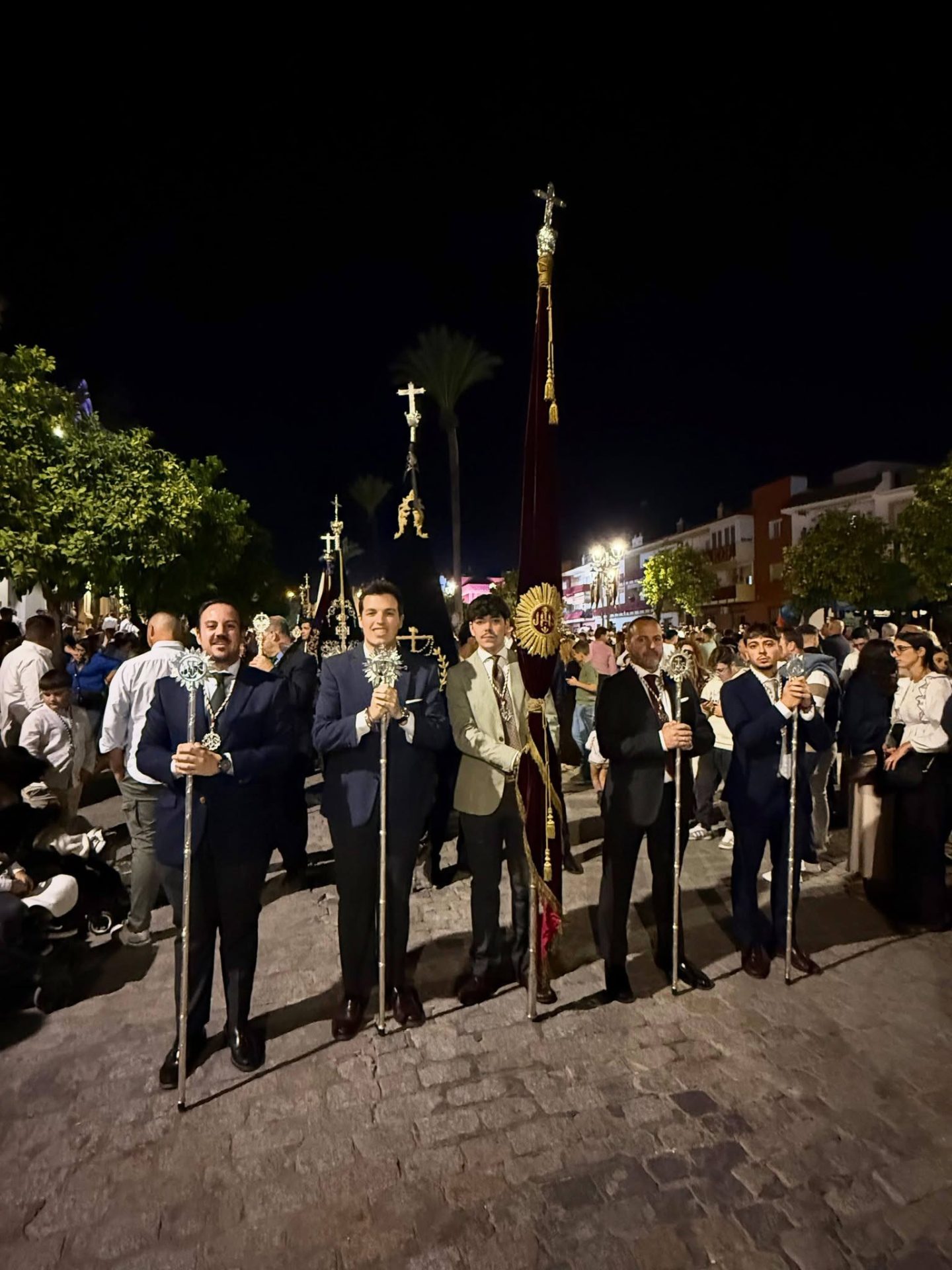 Representantes del Dulce Nombre de Marchena con estandarte y varas en Paradas; fotografía difundida por la hermandad en su Facebook oficial